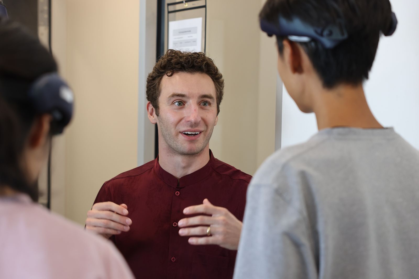 A General Neuro team member talks with Virginia Tech trial participants wearing NeuroLingo headbands