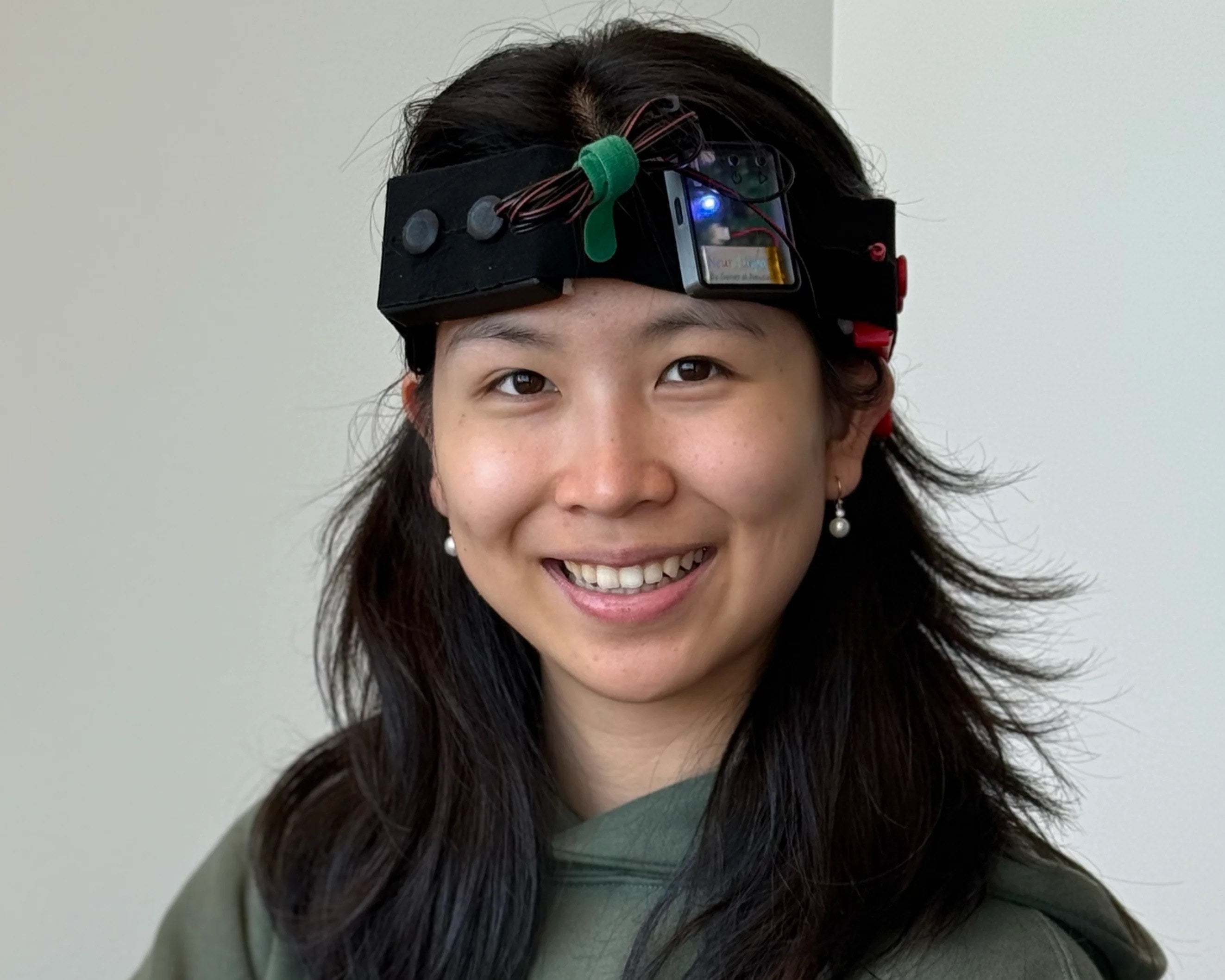 Original General Neuroscience tES prototype: a black headband holding electrodes, a small enclosure with onboard electronics, and a status indicator