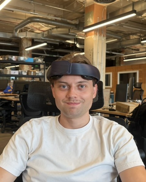 A team member at his desk wearing the v5 NeuroLingo headset