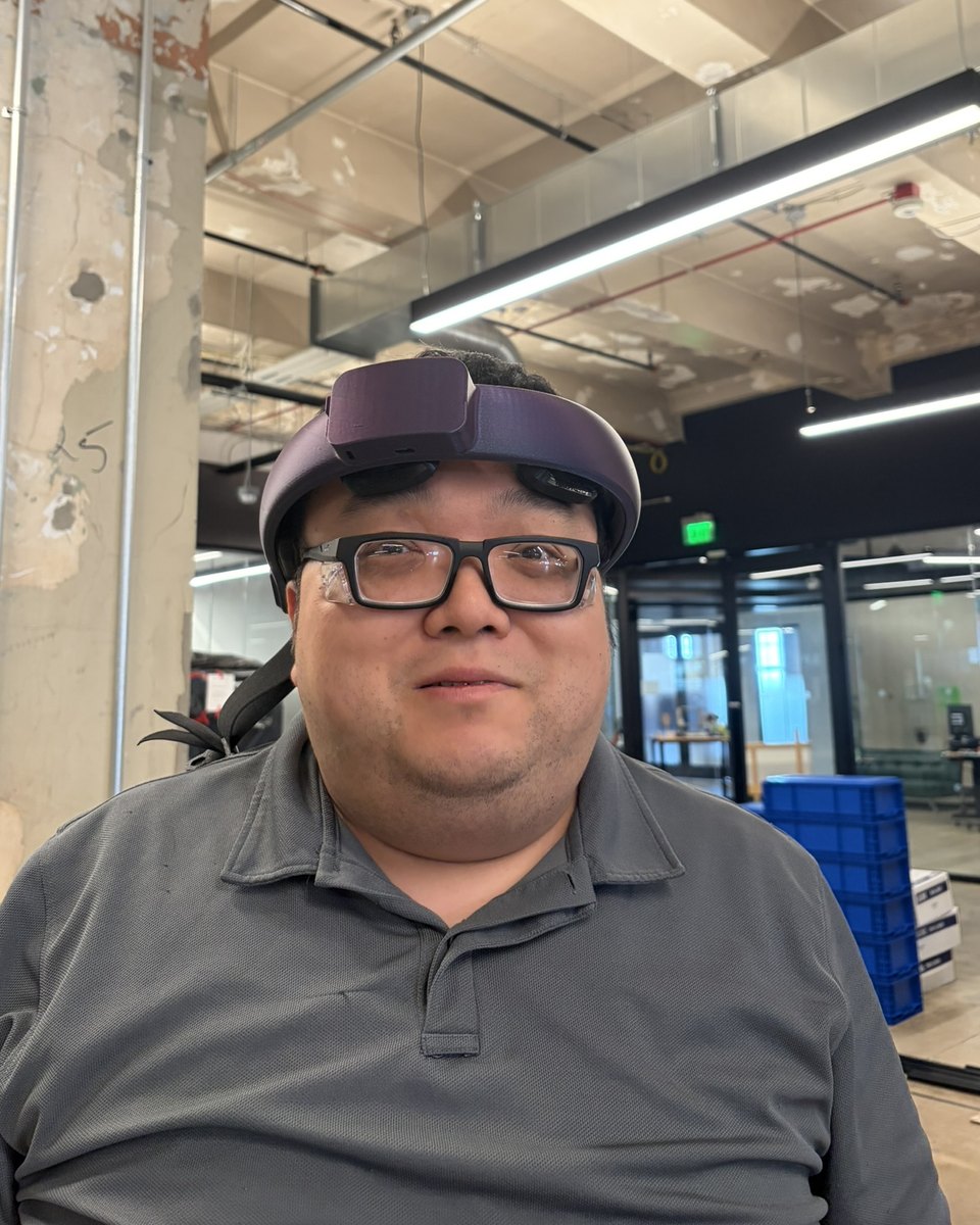A team member in glasses wearing the v5 NeuroLingo headset