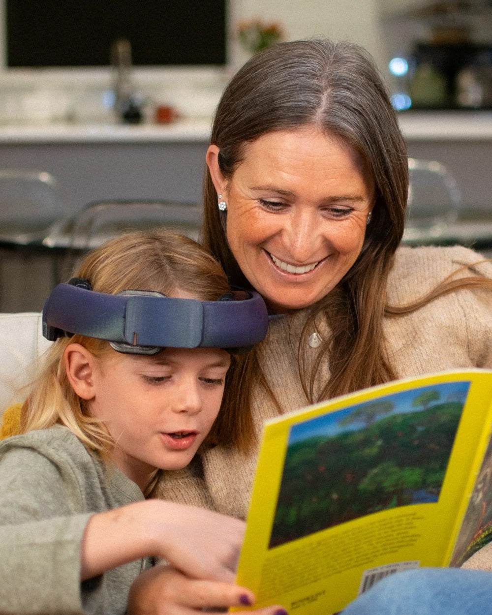 A child wearing the NeuroLingo headband reads a book with a parent